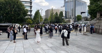 【写真２】靖国神社前で国葬儀会場に向け哀悼の気持ちを示す人たち