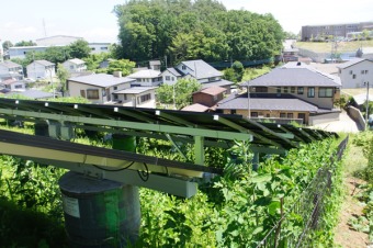 （写真5）住宅地に隣接した南向き斜面に建設された太陽光発電。足場はドラム缶